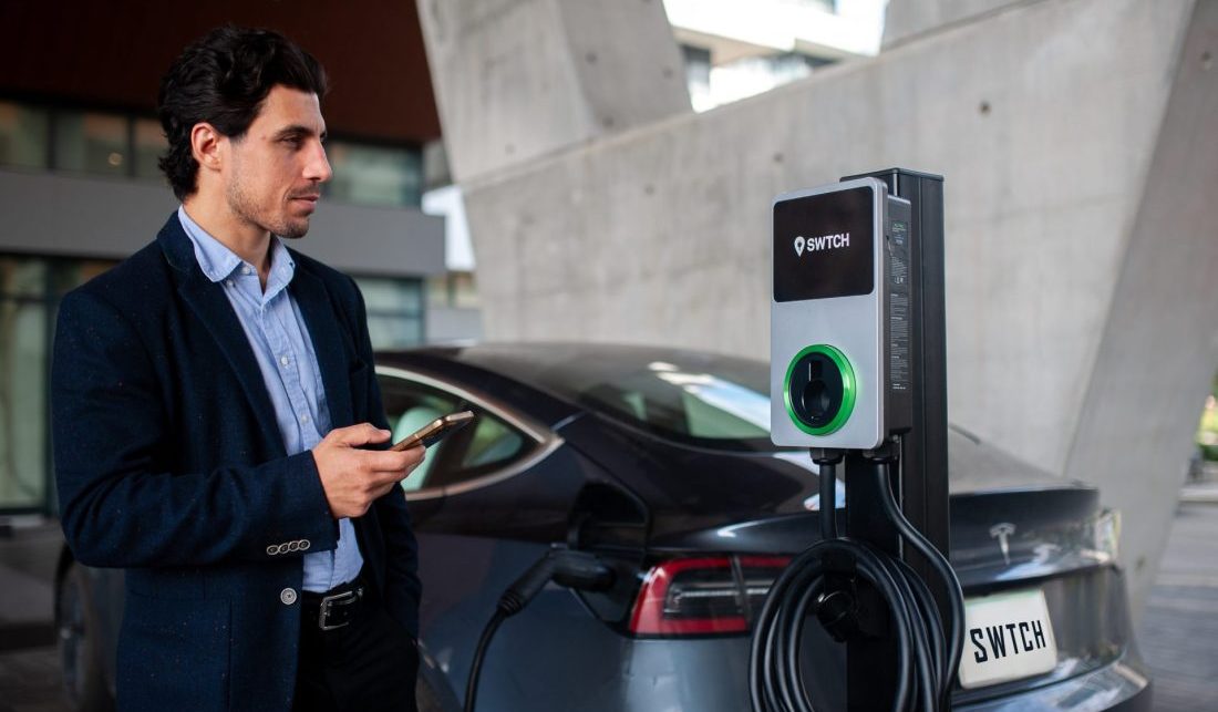 A man using a card to pay for a charging session at an electric car charger