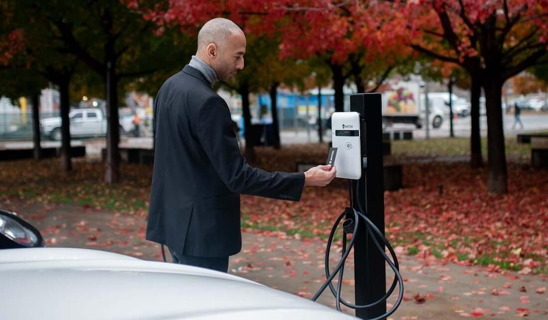 A man using an EV charger powered by SWTCH charging software