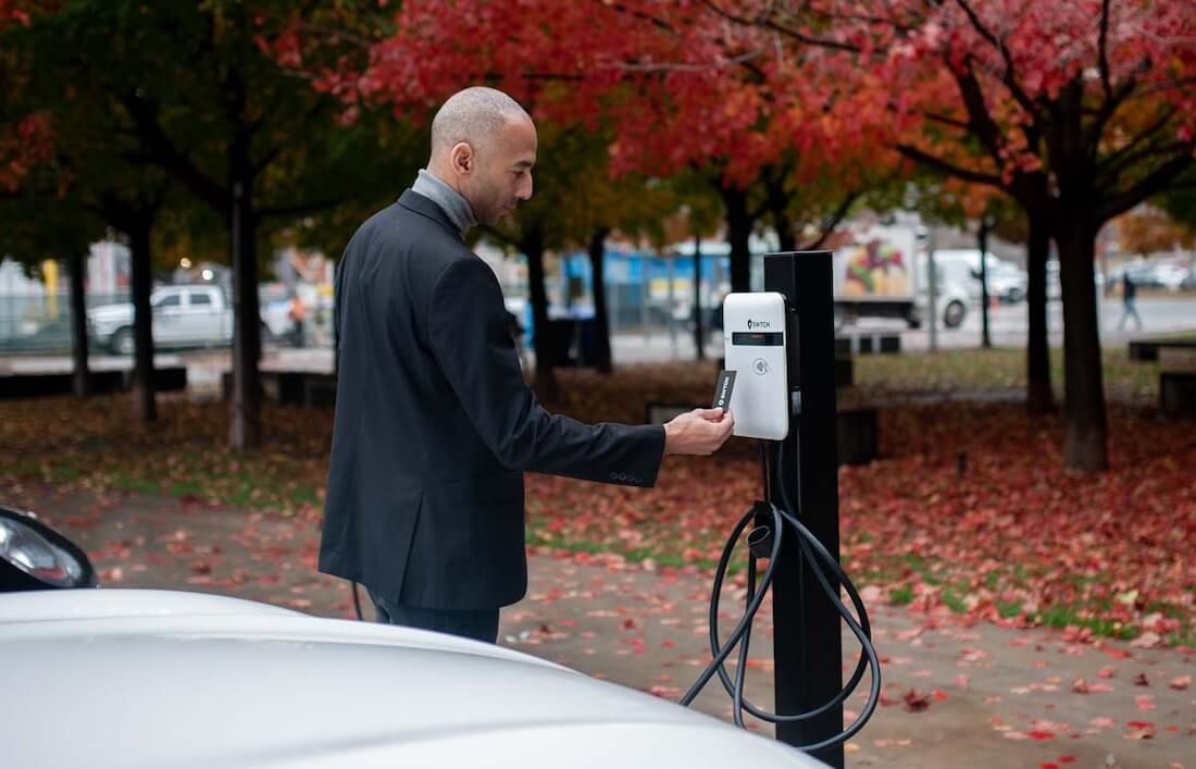 A man using an EV charger powered by SWTCH charging software